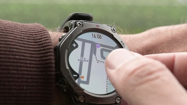 Close-up of finger zooming offline map on rugged smartwatch for outdoor navigation