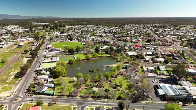 Cato Park lake, Stawell, Victoria, Australia &ndash; 4K aerial drone view of landscaped gardens, bowling greens, historic town centre and residential neighbourhoods near the Grampians in the morning