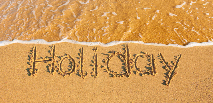 Das wort Holiday in den Sand geschrieben