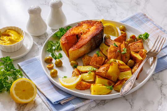 Crispy grilled salmon steak with potato wedges