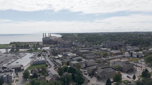 Port Washington, Wisconsin - 23 September 2026: Aerial view of the town of Port Washington with green trees, buildings, and roads under a cloudy sky.