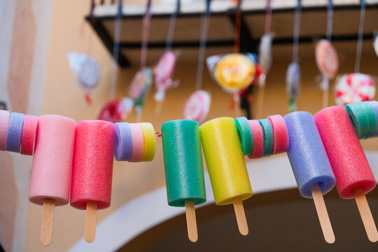 Details of colorful La Vila Joiosa town. Bright Foam Popsicle Garland and Candy Decorations at Street Festival in Villajoyosa, Spain