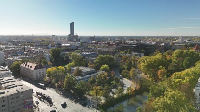 Aerial view of Wrocław city center with Sky Tower skyscraper, city moat park and colorful autumn trees on a sunny day, Poland