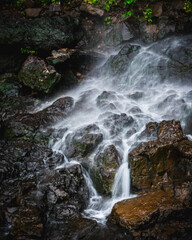 Aerial view of a waterfall cascading over dark wet rocks in a lush landscape, Karad, Maharashtra, India. © Travel 'n' Lifestyle