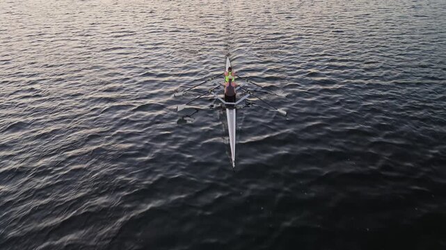 Aerial footage of Halifax Harbour during an early morning rowing session, with women and men training separately in single boats and together in two-person racing shells.