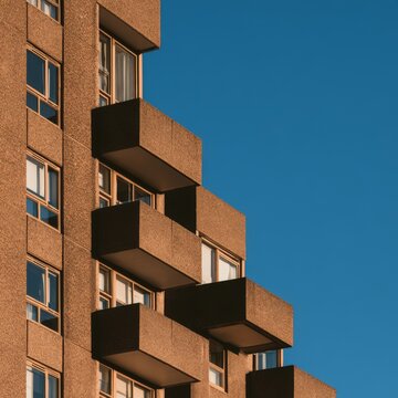 Angular brick balconies beneath a clear deep blue sky