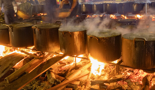 Traditional Vietnamese b&aacute;nh chưng simmering in steaming pots over open fires during the night in Lunar New Year in Tam Coc, Vietnam