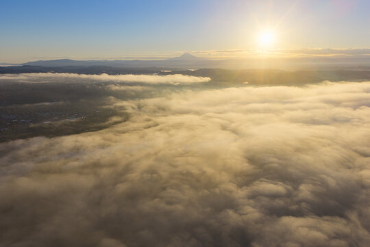 Sunrise illuminates low clouds drifting through the Willamette Valley, just south of Portland, Oregon. This scenic Pacific Northwest region is less than an hour drive from Mt. Hood.