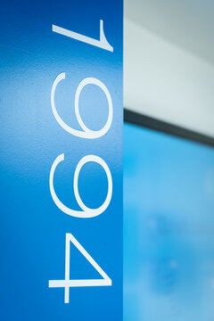 View of the number 1994 displayed in white typography on a vibrant blue wall in an office setting in London, United Kingdom.