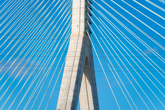 View of the Flintshire Bridge with its concrete pylon and steel cables stretching against a clear blue sky in Deeside, Wales, United Kingdom.