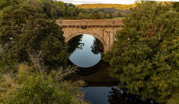 The Dundas Aqueduct bridge creates a reflection at sunset near Bath.
