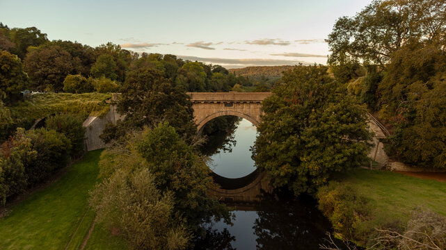 A tranquil evening view of a historic Dundas Aqueduct spanning a river.