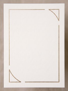 White card with a minimalist champagne gold foil frame, featuring geometric corner accents and thin linear borders on a textured paper surface