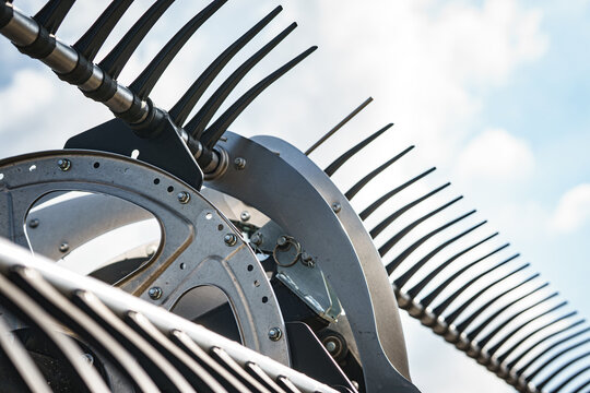 View of the metallic reel and tines of a modern combine harvester during a canola harvest in Cherkasy, Cherkasy Oblast, Ukraine.