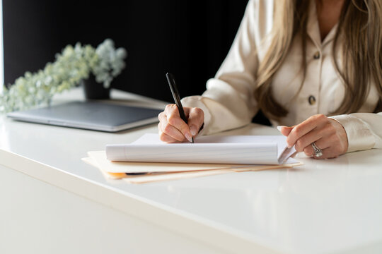 Hands Writing in Notebook at Desk