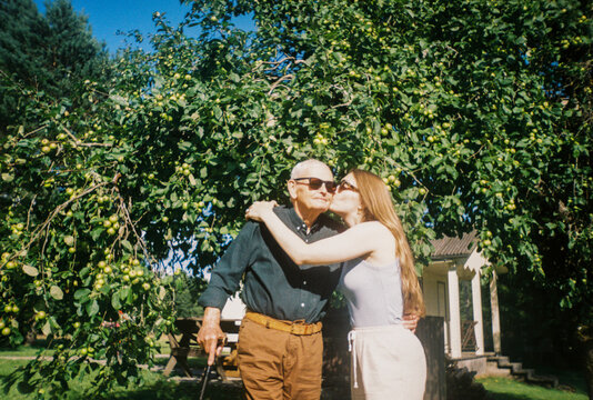 Old Man With His Daughter Stands Under an Apple Tree