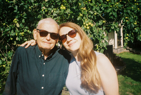 Senior Man With His Daughter Under an Apple Tree