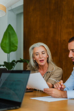 Female executive explaining document during meeting in office