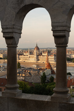 Hungarian Parliament seen through stone arches in Budapest