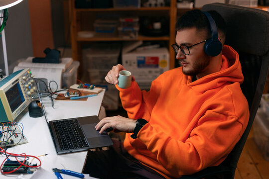 Young Hacker Working on Laptop in Home Workshop