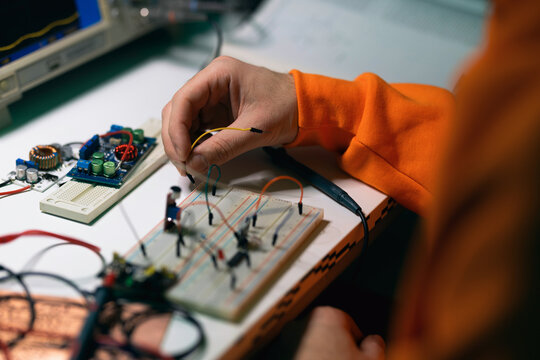 Engineer Assembling Electronic Circuit on Breadboard Prototype