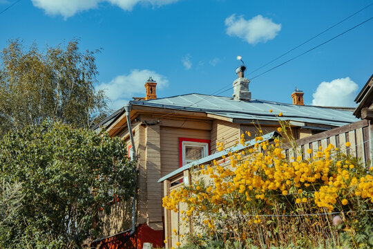 Wooden house with yellow flowers under a blue sky