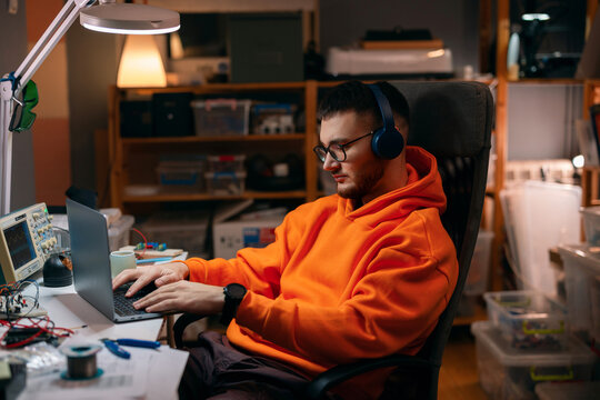 Young Programmer Working Late In Electronics Workshop