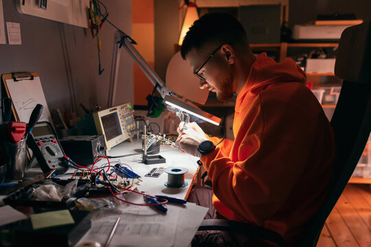 Electronics Engineer Soldering Circuit Board at Workbench