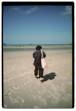 Walking on the beach with blue sky and water ahead