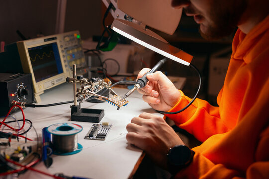 Electronics Engineer Soldering Circuit Board at Workbench