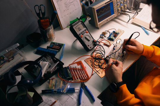 Electronics Engineer Soldering Circuit on Breadboard in Workshop