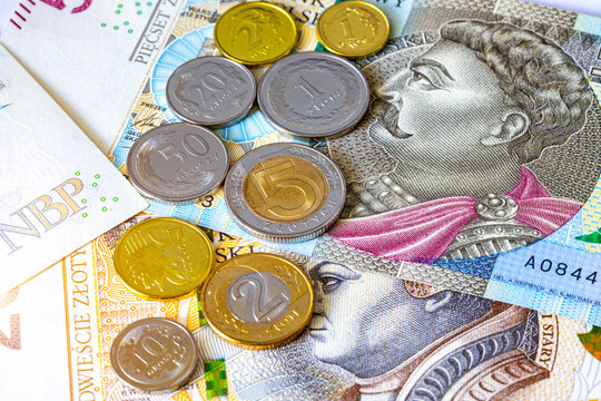 Polish zloty coins rest on top of 200 and 500 zloty banknotes. Polish national currency PLN. European finance.