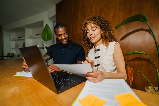 Colleagues reading document at table in workplace