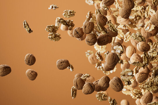 Walnuts and Kernels Bursting Across Brown Background