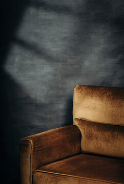 golden Chair Against a Dark Blue Wall With Shadow Patterns