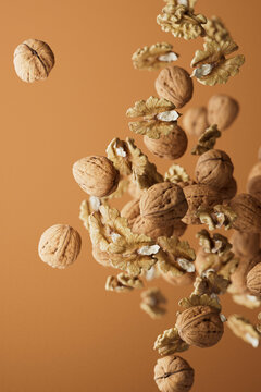 Falling Walnuts and Kernels on Brown Background