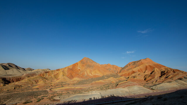 Sunlit multicolored eroded mountain ridges and rocky badland terrain