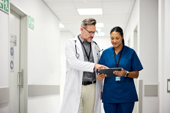 Two medical professionals look at a tablet together