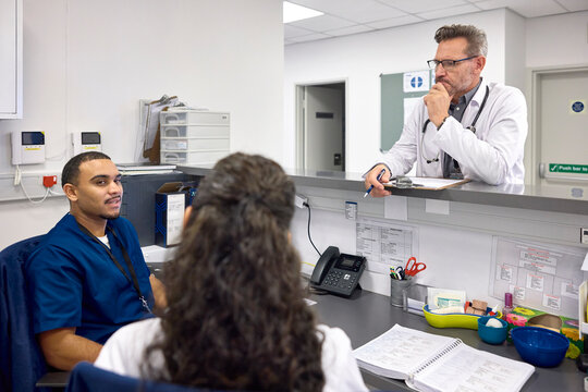 Doctors chat at a hospital desk