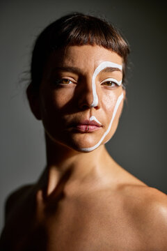 Portrait of a woman with artistic face paint in a studio setting