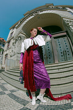 Bold Woman in Velvet Look on European old town street on fisheye lens