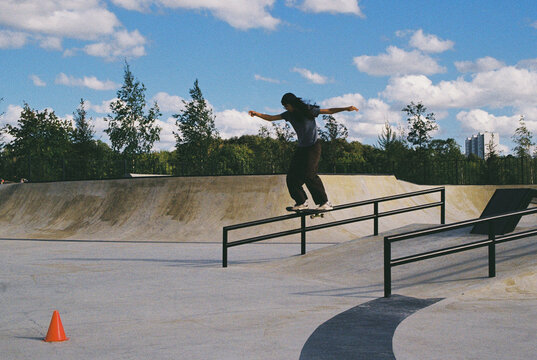 Skater performing a trick at a skate park on a sunny day