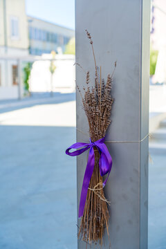 A bundle of dried lavender stems tied with a vivid purple satin ribbon is displayed at street in Koper, Slovenia
