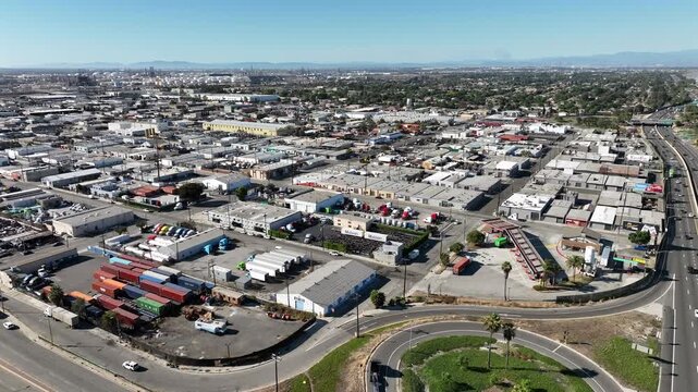 Long Beach, California, USA - Aerial View of Westside Industrial District Near 710 Freeway With Factories, Large Warehouses and 18-Wheeler Trucks on a Bright Day