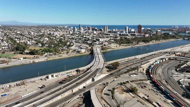 Long Beach, California, USA - Leftward Drone View of Busy 710 Freeway Under Construction Along Los Angeles River With Residential Neighborhoods and Downtown Skyline on a Bright Day