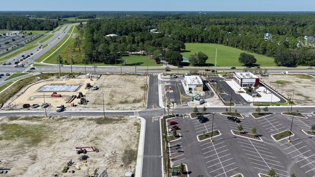 Aerial view of the intersection at Foundry Lane and International Golf Parkway, showing a new commercial development with a parking lot in World Golf Village, Florida, United States.
