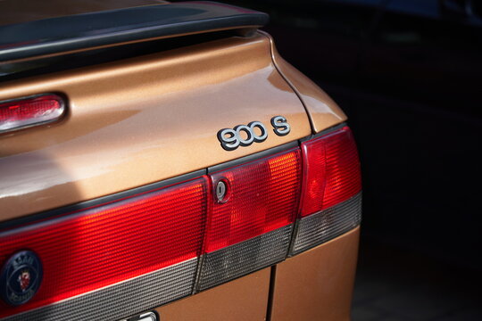 Close-up detail of chrome 900 S model emblem badge, rear light reflector lens and trunk lock on bronze Saab 900 Convertible body, Subotica, Serbia - June 6, 2026