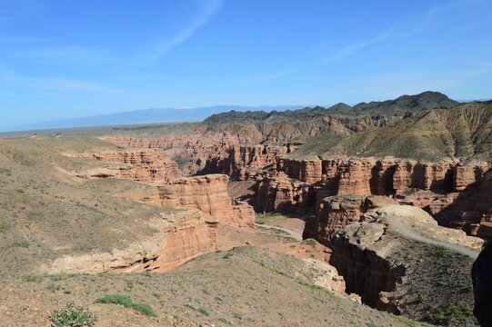 Panoramic view of red sandstone canyon and arid mountain landscape