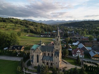 Chochołów - Polska  Panorama Chochołowa razem z kościołem i Tatrami na horyzoncie. Góry, pola, kościół, zdjęcie wykonane drone, lato, wiosna ,jesień © Konrad