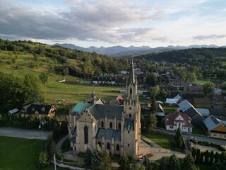 Chochołów - Polska  Panorama Chochołowa razem z kościołem i Tatrami na horyzoncie. Góry, pola, kościół, zdjęcie wykonane drone, lato, wiosna ,jesień © Konrad